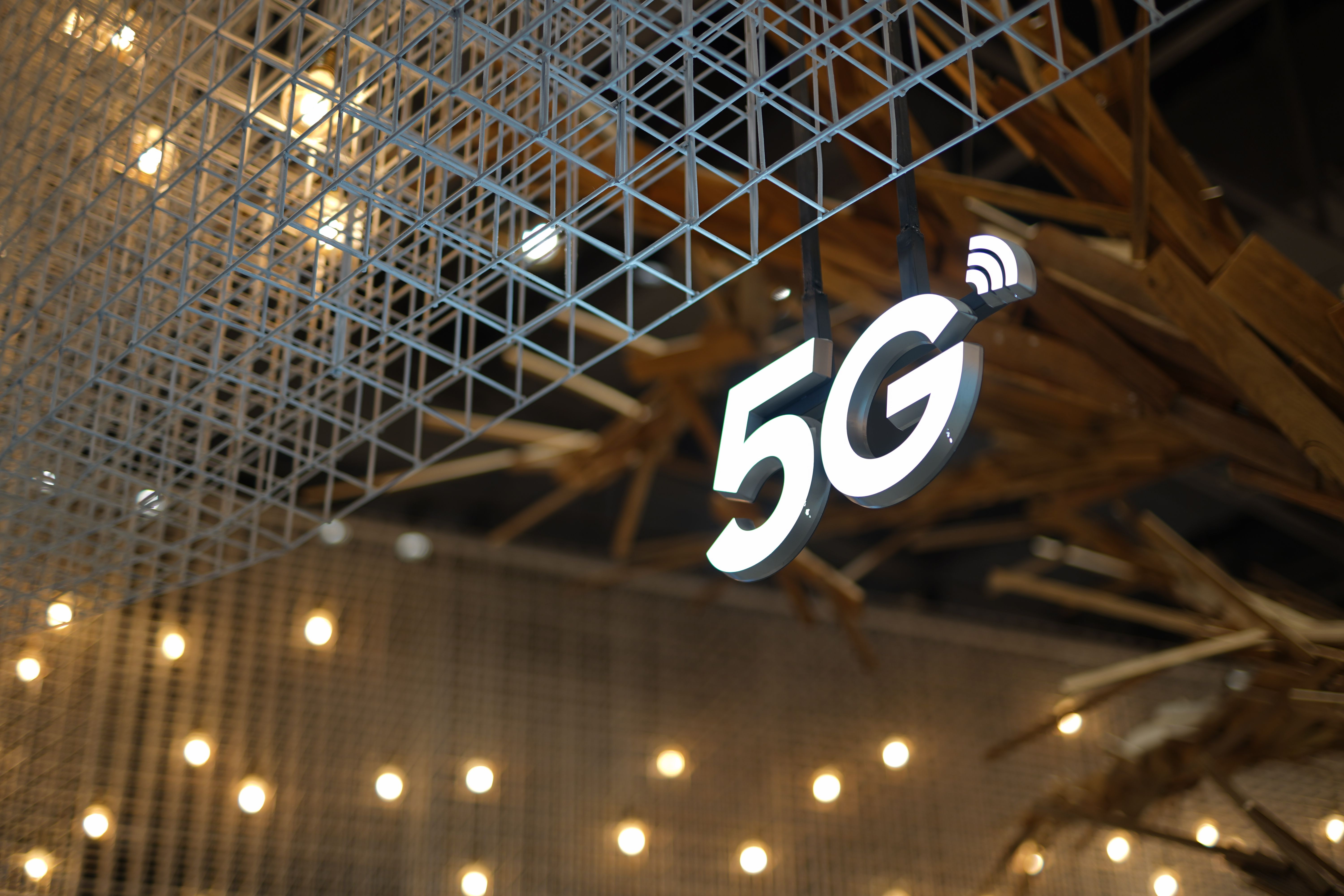 실내 천장에 매달린 5G 표시와 통신 네트워크 구조물